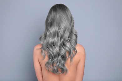 Image of Woman with gray hair on grey background, back view