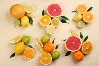 Photo of Flat lay composition with tangerines and different citrus fruits on beige background