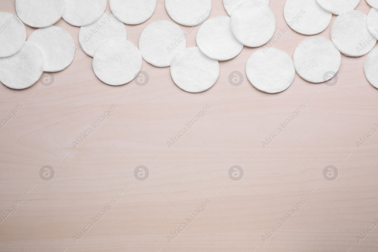 Photo of Many clean cotton pads on wooden table, flat lay. Space for text