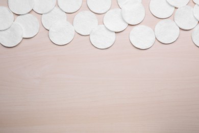 Photo of Many clean cotton pads on wooden table, flat lay. Space for text