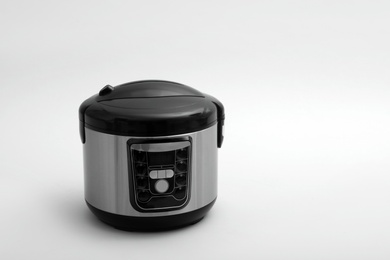 Photo of Modern electric multi cooker on light background. Space for text