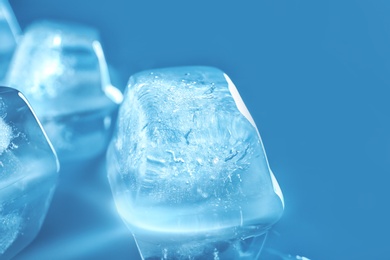 Photo of Transparent ice cubes on color background, closeup