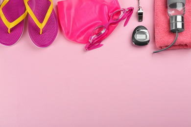 Photo of Flat lay composition with swimming accessories on pink background. Space for text