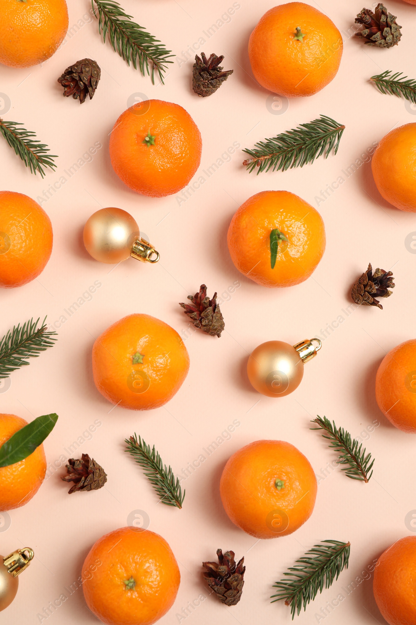 Photo of Composition with Christmas balls and tangerines on beige background, flat lay