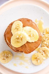 Photo of Banana pancakes with honey on plate, top view