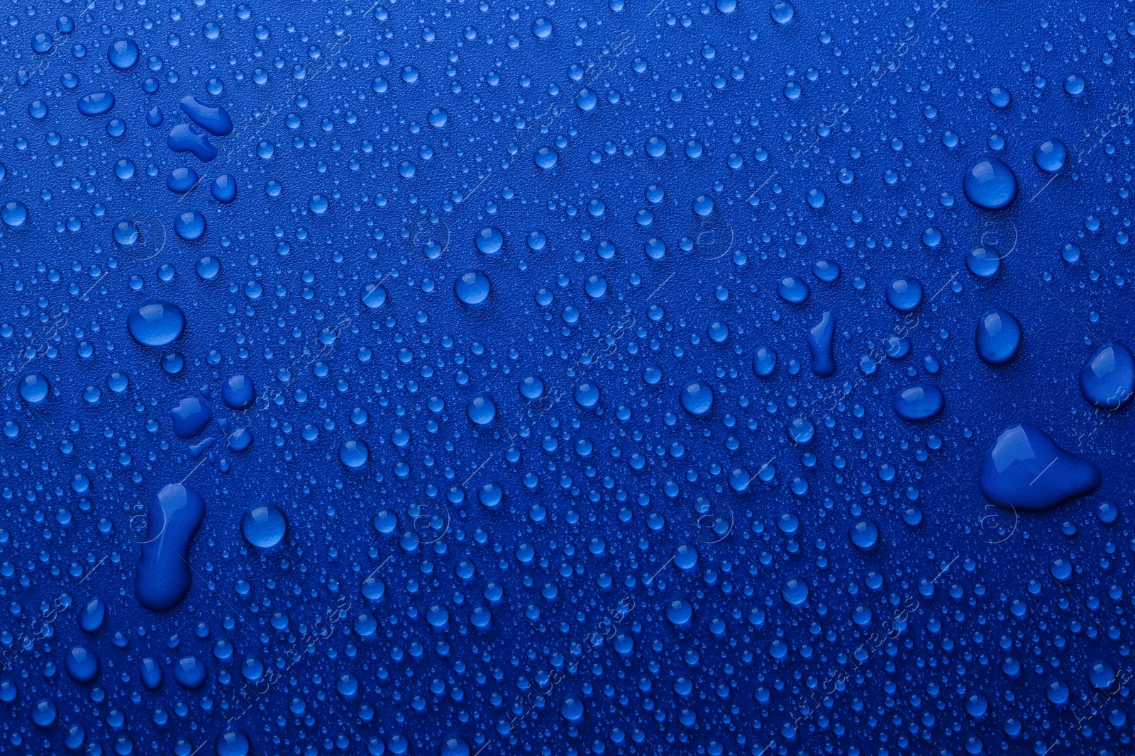 Photo of Water drops on blue background, top view