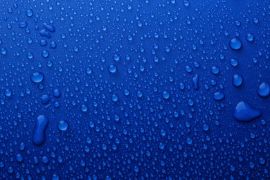 Photo of Water drops on blue background, top view