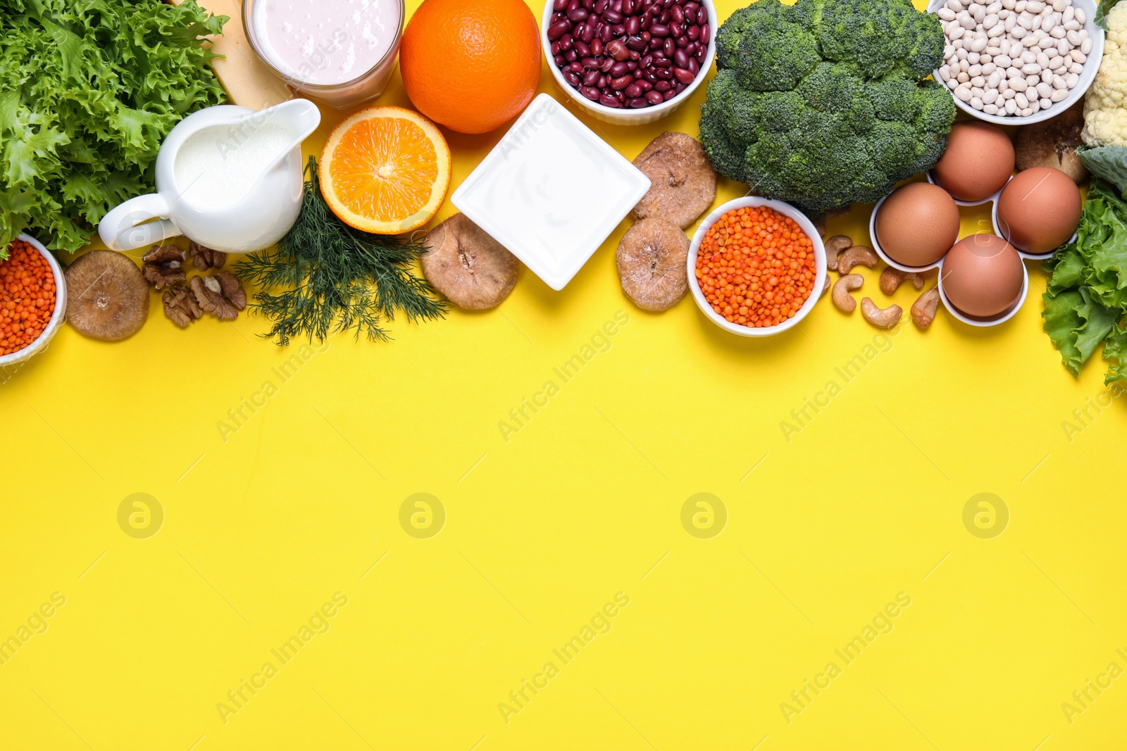 Photo of Food high in calcium. Flat lay composition with different products on yellow background, space for text