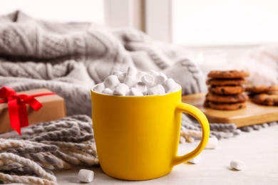 Photo of Cup of hot cocoa with marshmallows on window sill. Winter drink