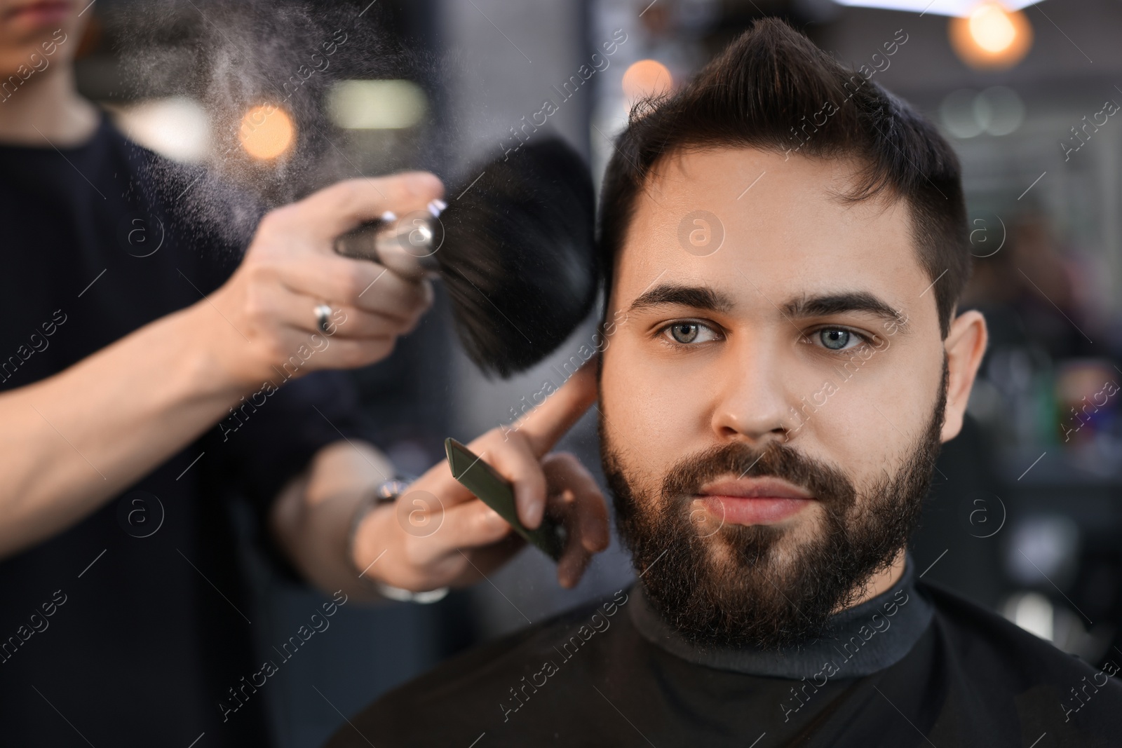 Photo of Professional hairdresser working with client in barbershop