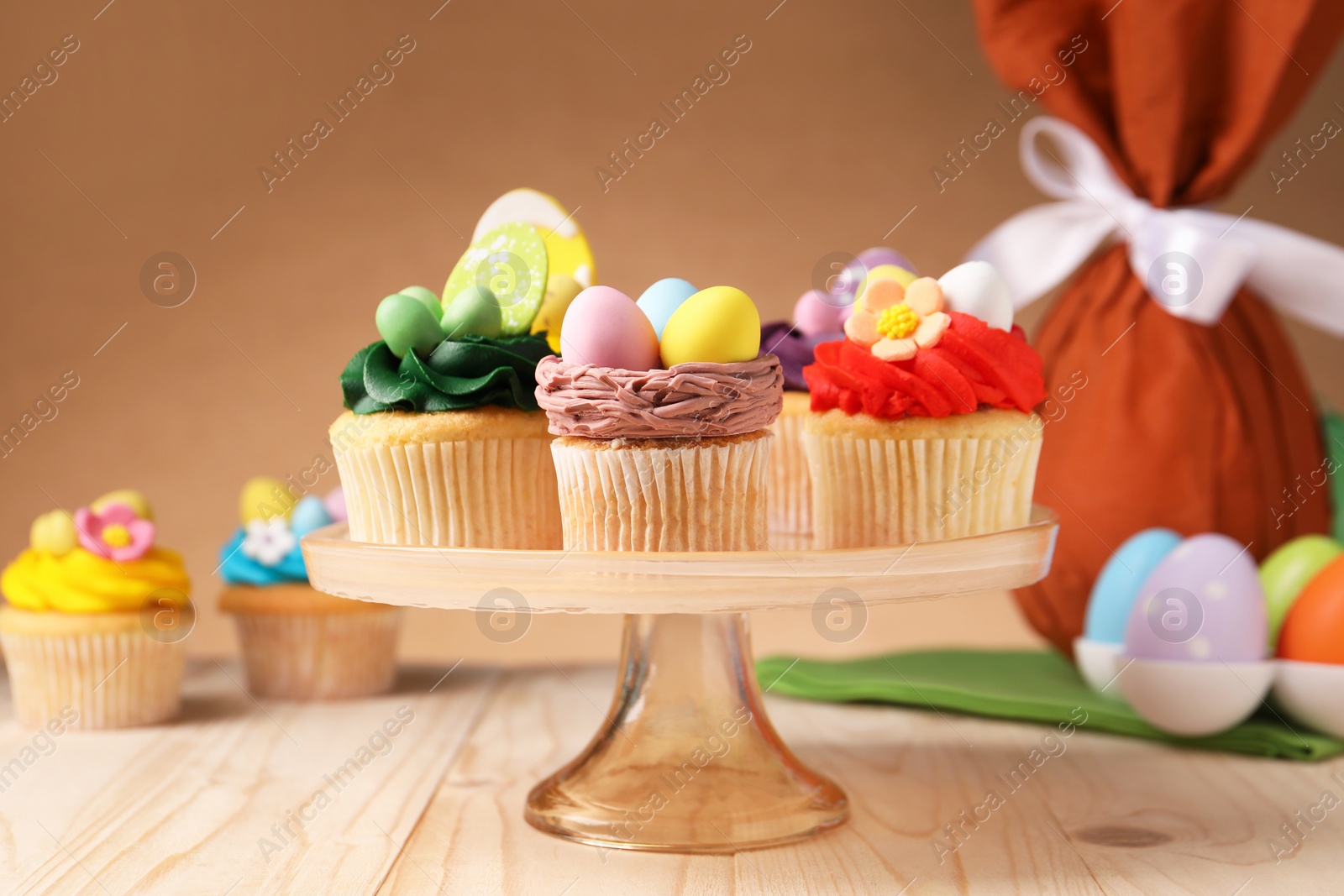 Photo of Tasty cupcakes with Easter decor on wooden table