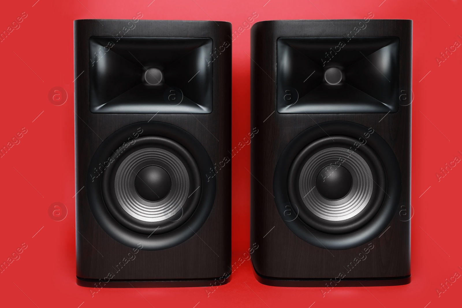 Photo of Modern wooden sound speakers on red background