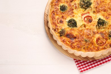 Delicious homemade vegetable quiche on white wooden table, top view. Space for text