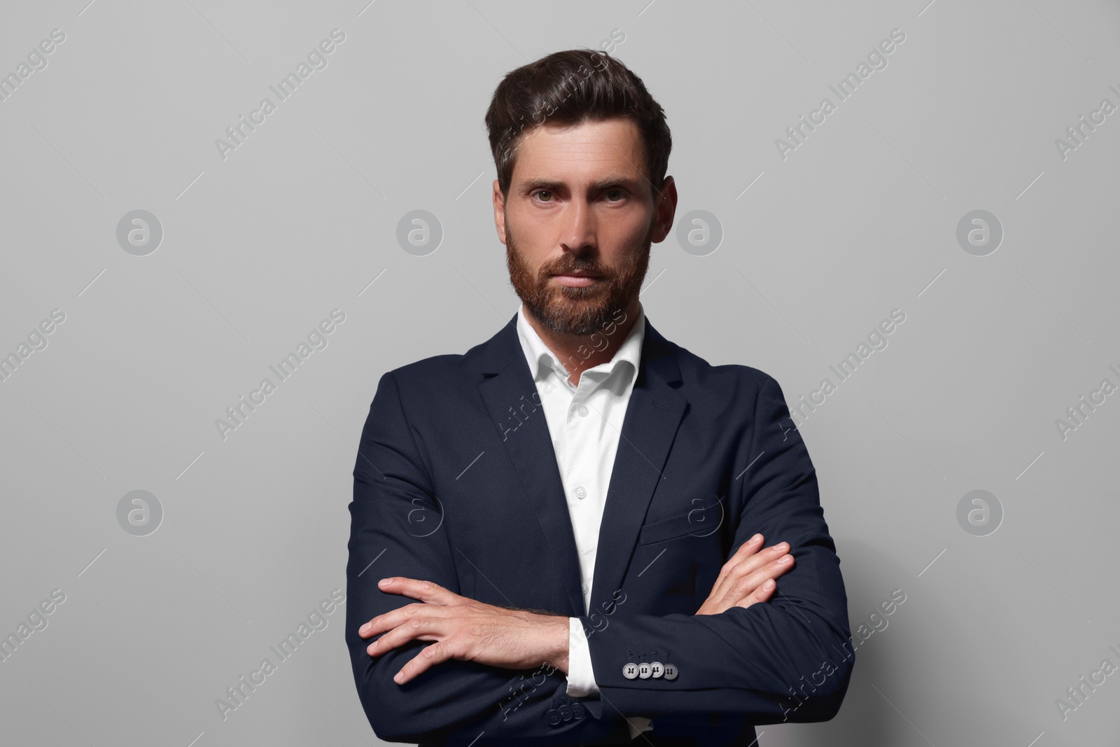 Photo of Portrait of handsome bearded man in suit on light grey background