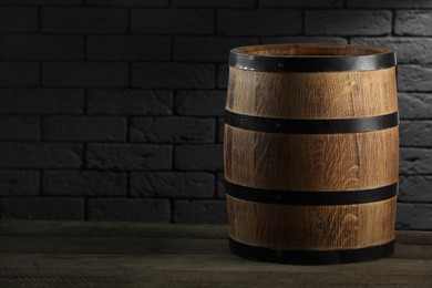 One wooden barrel on table near brick wall. Space for text