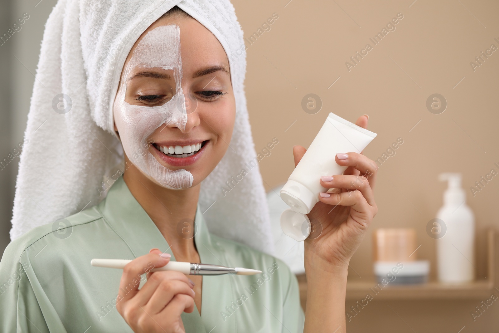 Photo of Woman with face mask and brush indoors, space for text. Spa treatments
