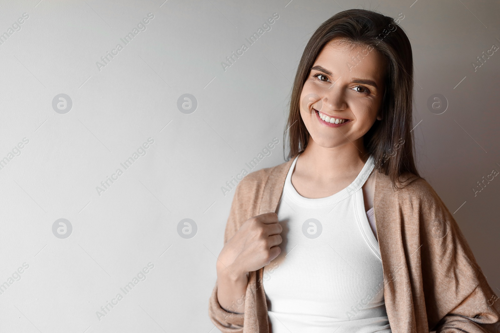 Photo of Portrait of beautiful young woman on beige background, space for text