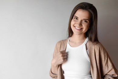 Photo of Portrait of beautiful young woman on beige background, space for text