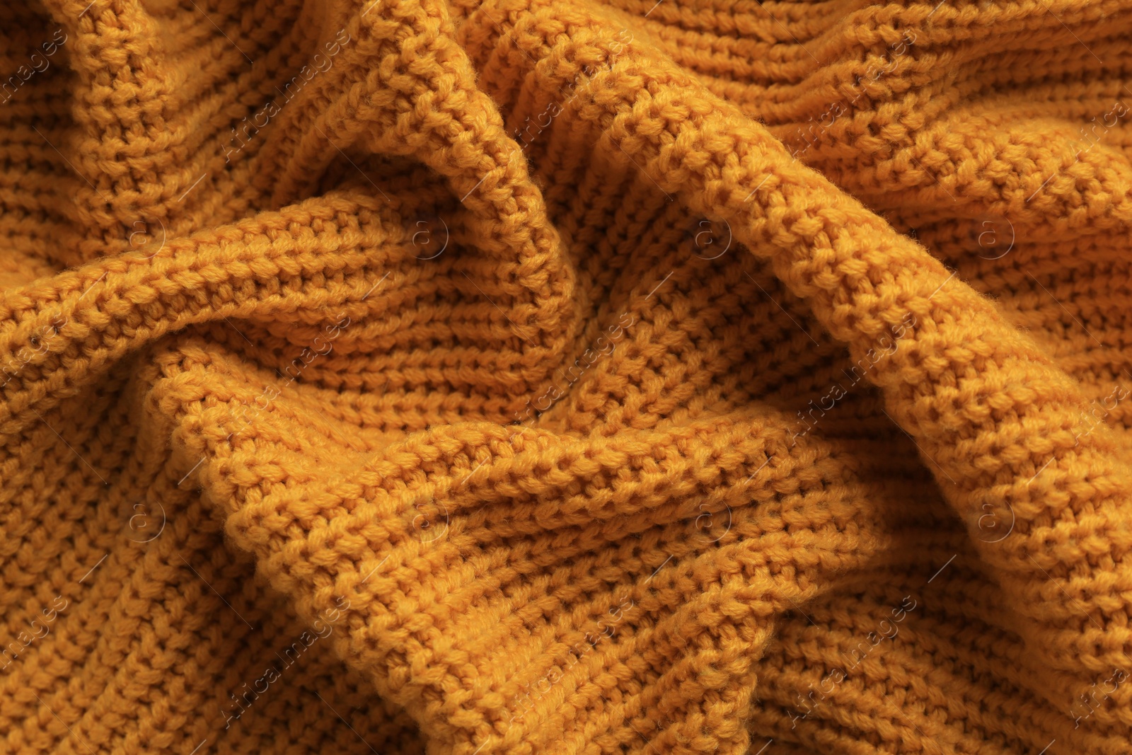 Photo of Beautiful orange knitted fabric as background, top view