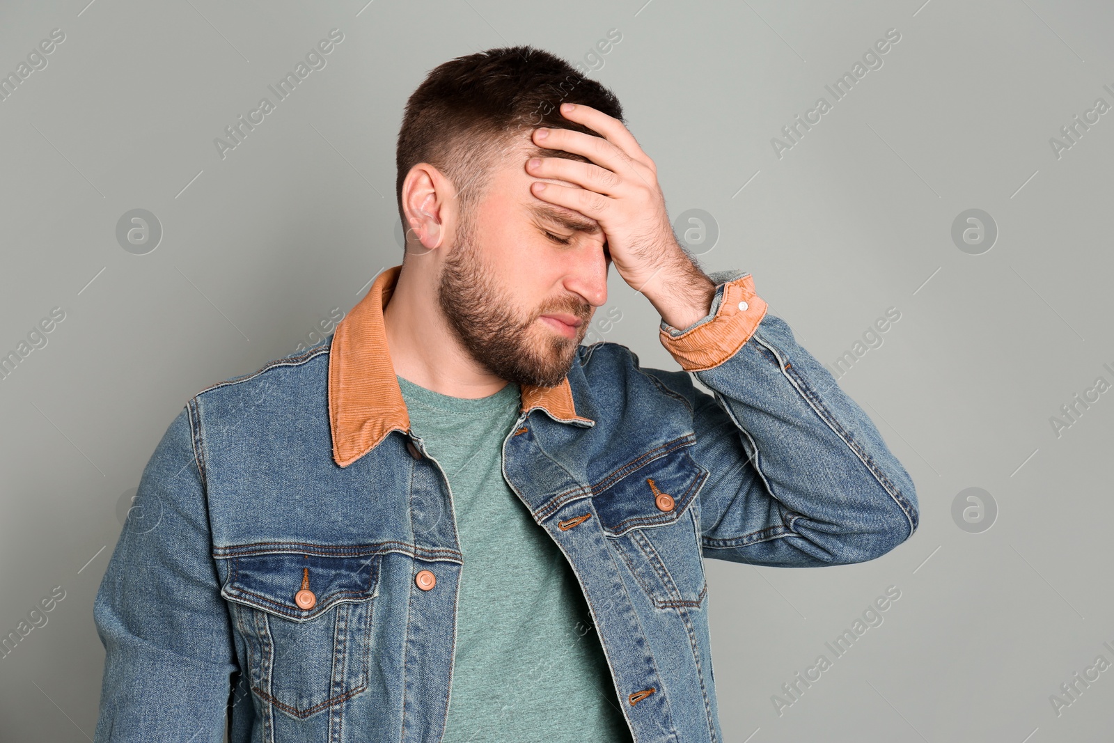 Photo of Man suffering from migraine on grey background