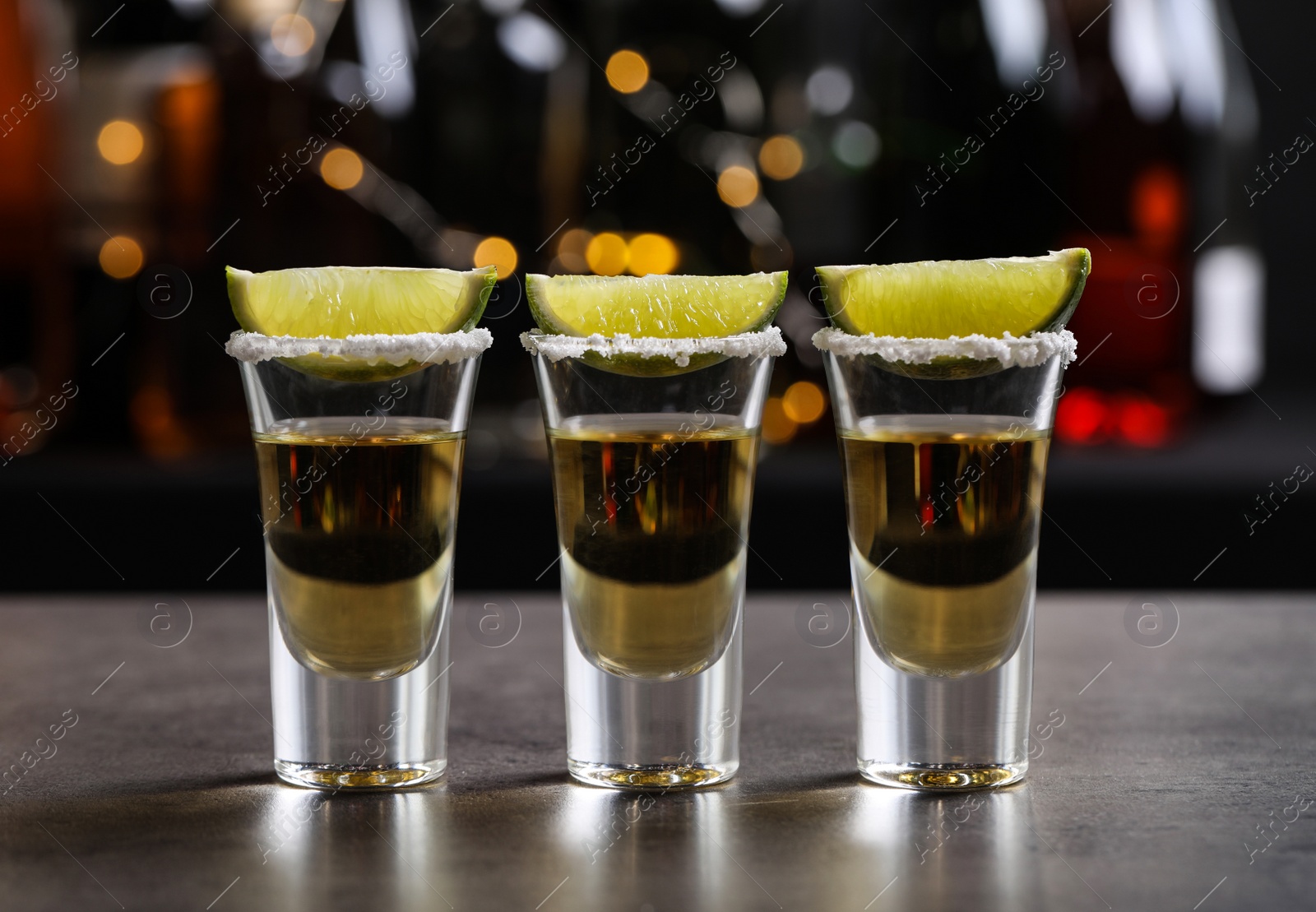 Photo of Mexican Tequila shots, lime slices and salt on bar counter