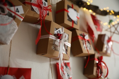 Photo of Handmade Advent calendar with gifts indoors, closeup. Christmas season