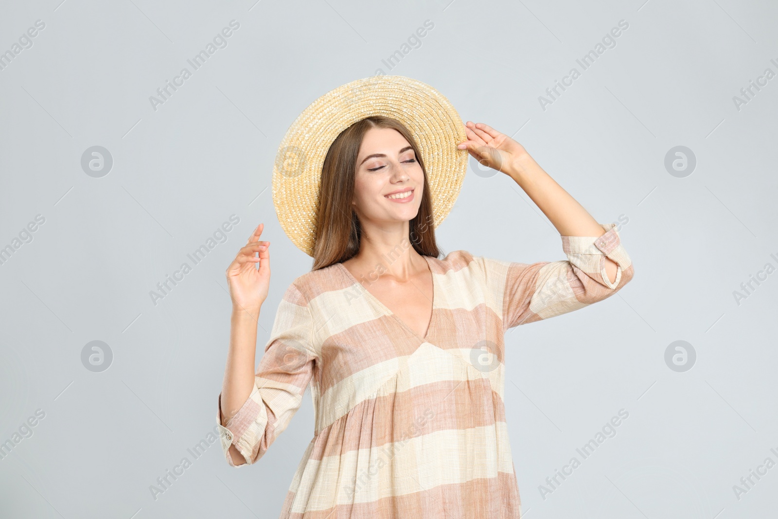 Photo of Young woman wearing stylish dress on light grey background