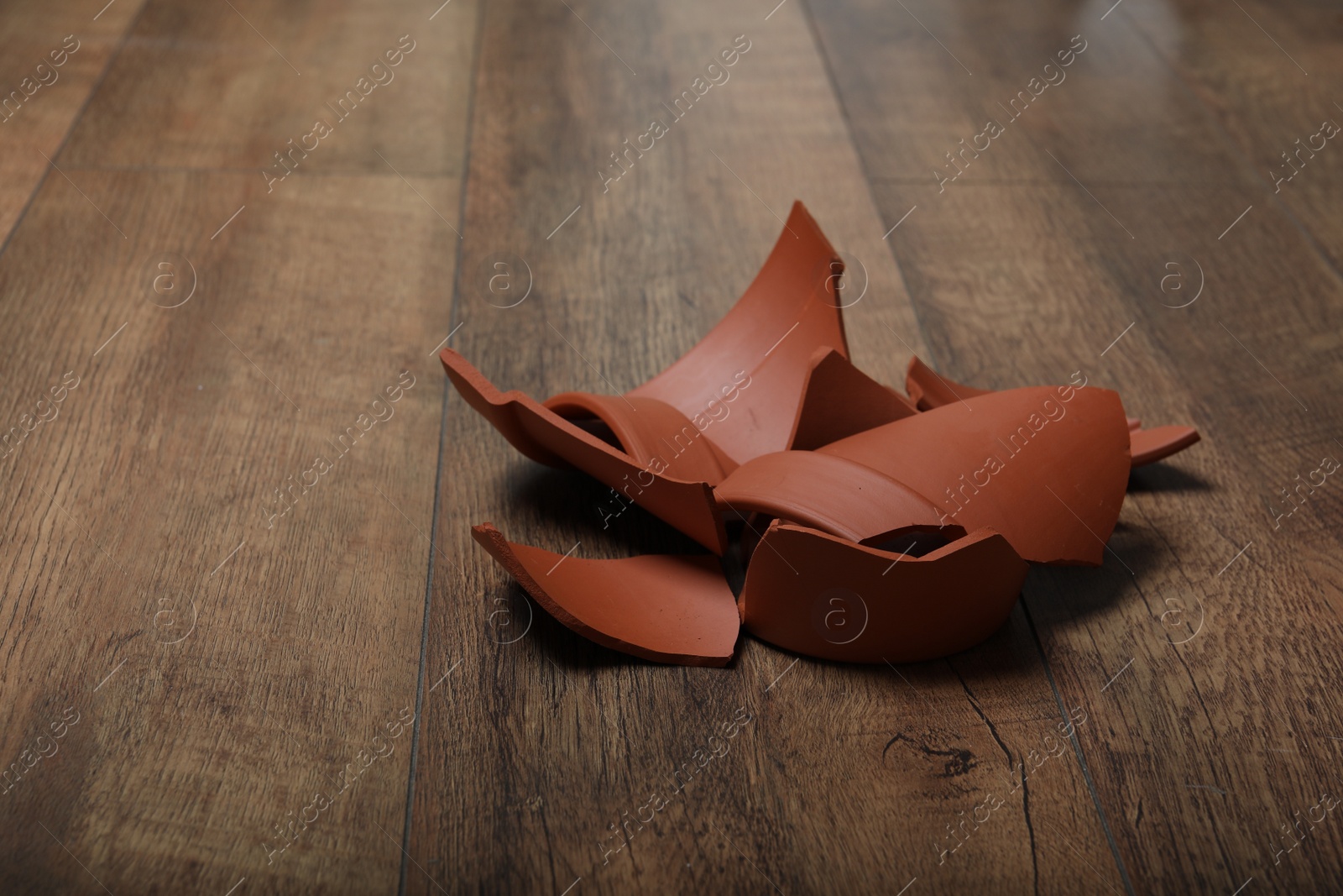 Photo of Broken terracotta flower pot on wooden background