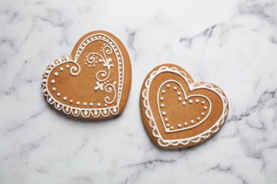 Tasty heart shaped gingerbread cookies on white marble table, flat lay