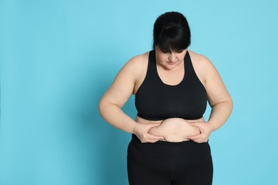 Photo of Obese woman on light blue background. Weight loss surgery