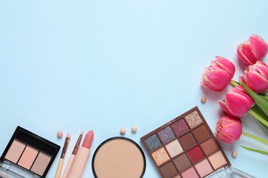 Flat lay composition with eyeshadow palettes and beautiful flowers on white background, space for text