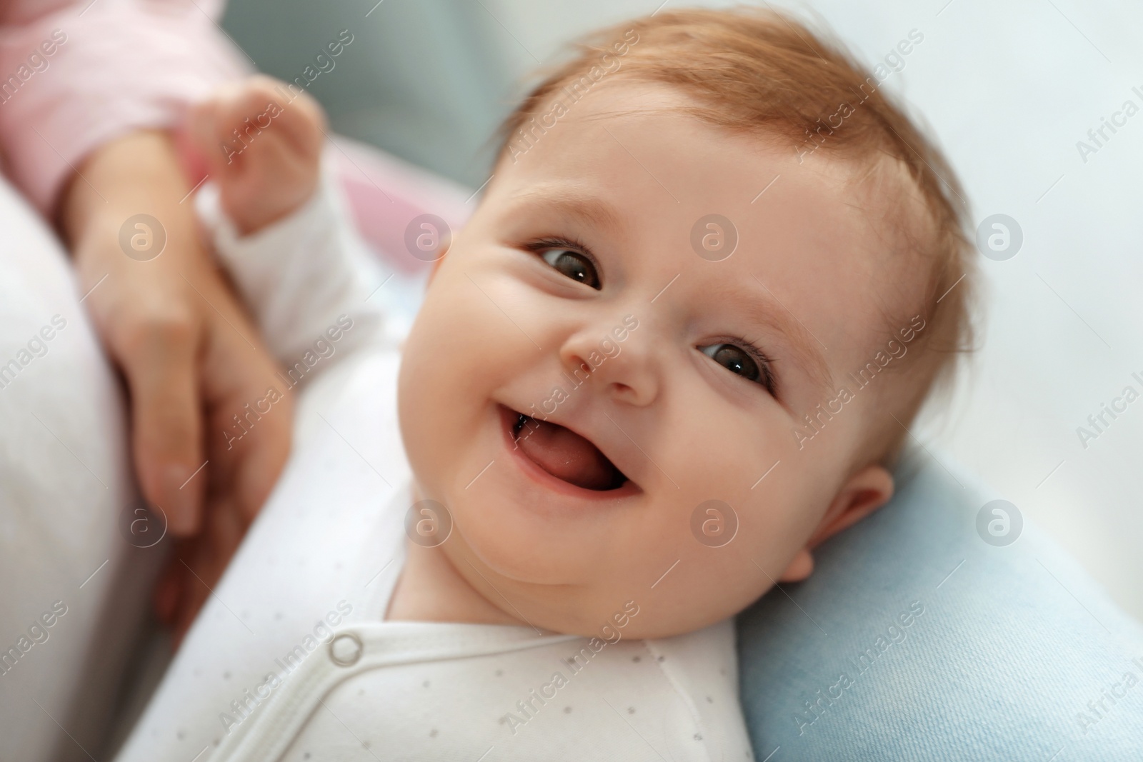 Photo of Young woman with her cute baby at home, closeup