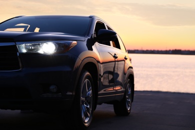 Photo of Modern new car on road near river