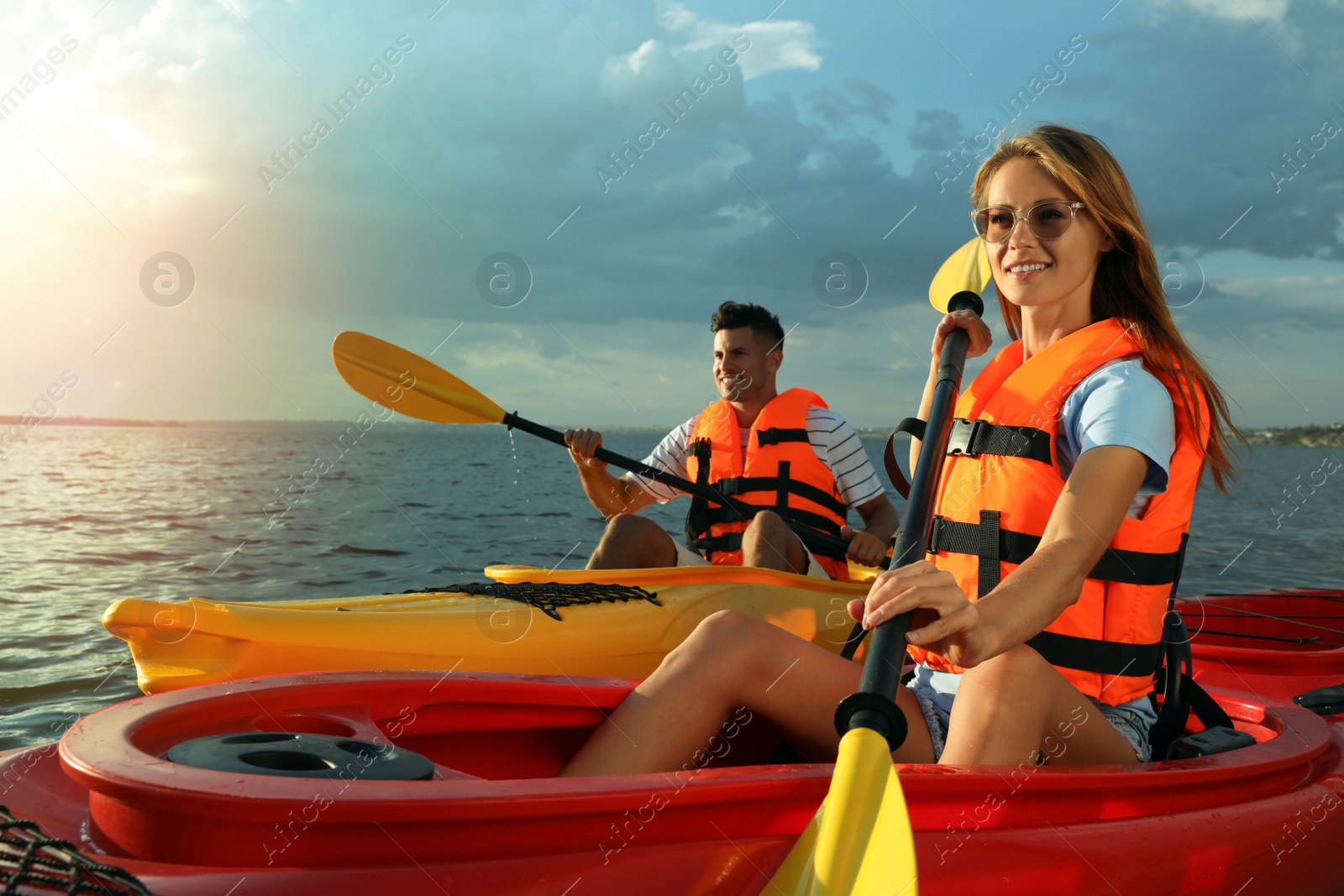 Photo of Couple in life jackets kayaking on river. Summer activity