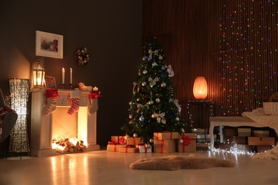 Photo of Stylish living room interior with decorated Christmas tree at night