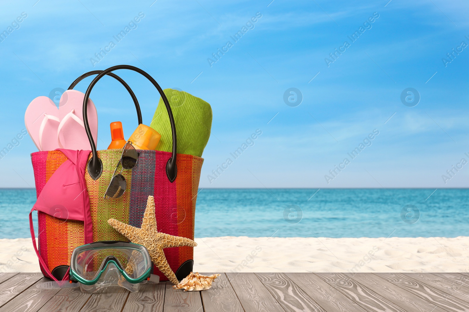 Image of Bag with scuba diving mask and accessories on sunny ocean beach, space for text. Summer vacation