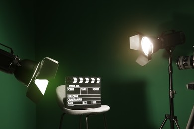 Chair with clapperboard under spotlight in studio