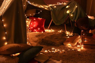 Beautiful play tent decorated with festive lights at home