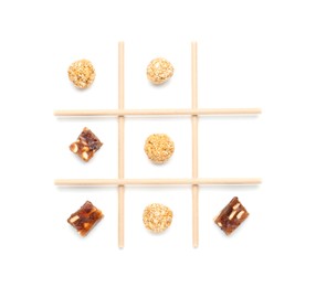 Photo of Tic tac toe game made with sweets isolated on white, top view