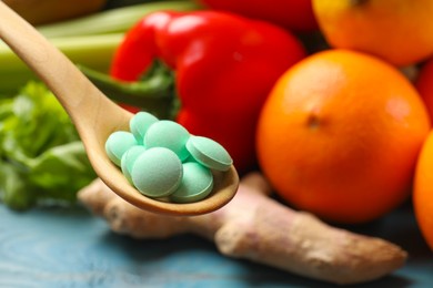 Photo of Dietary supplements. Spoon with pills over food products, closeup. Space for text