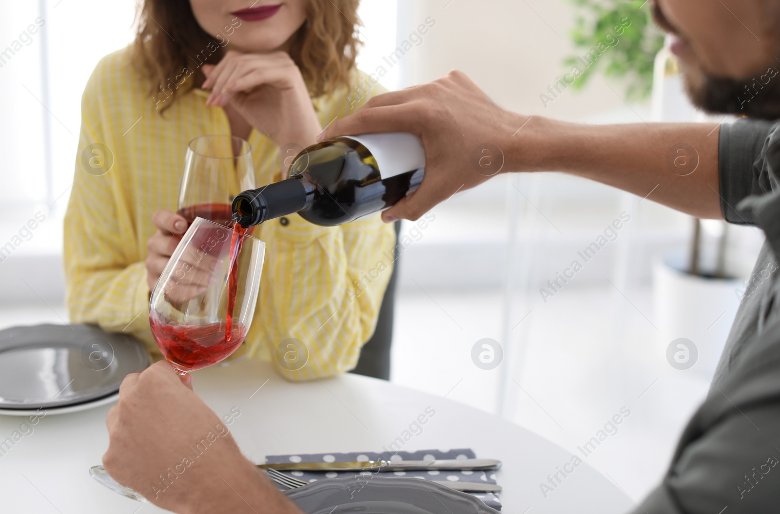 Photo of Young couple with glasses of wine at table in restaurant