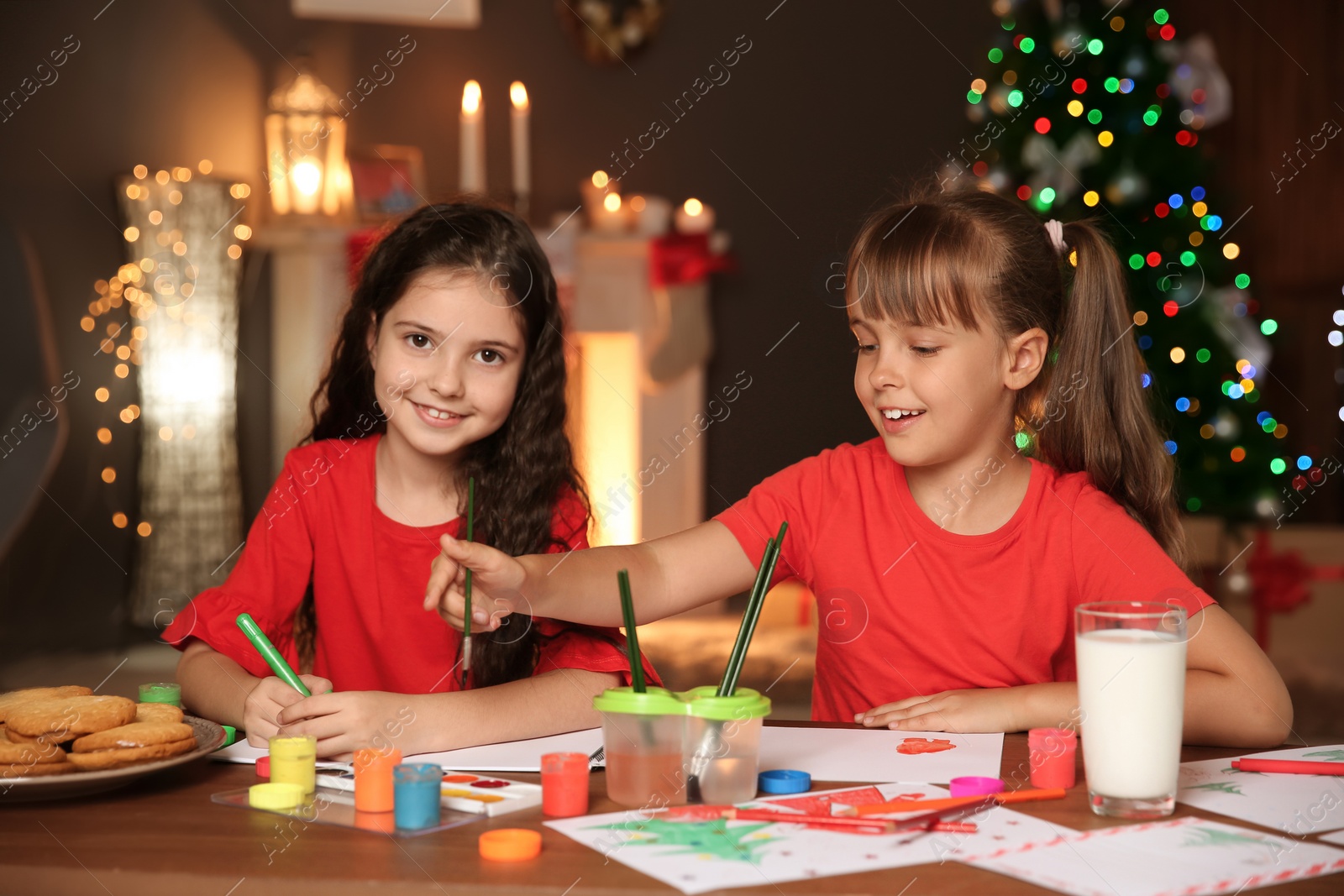 Photo of Little children drawing pictures at home. Christmas celebration