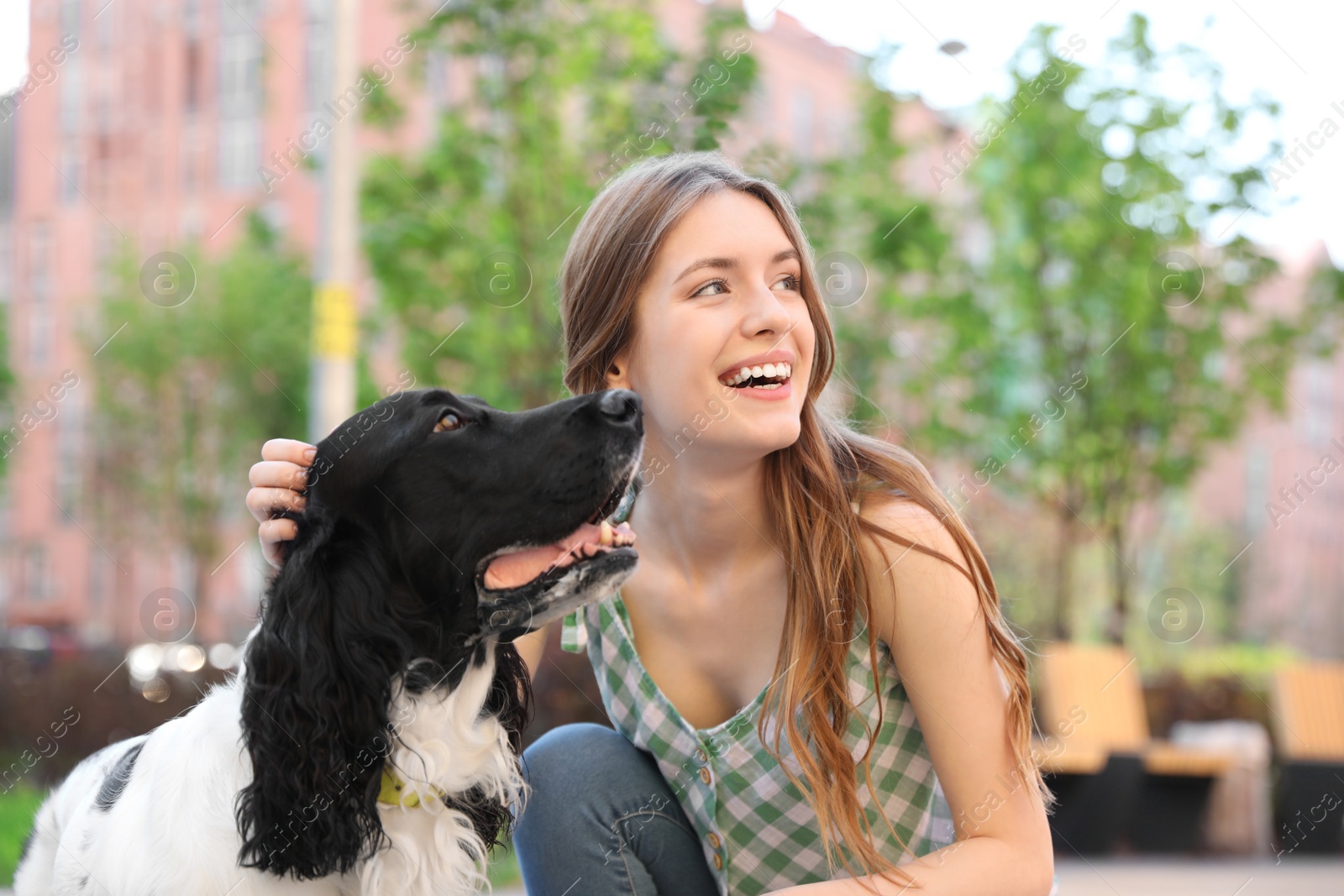 Photo of Young woman with her English Springer Spaniel dog outdoors