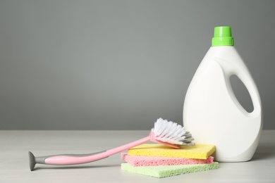 Photo of Bottle of cleaning product and supplies on light table. Space for text