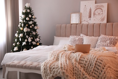 Photo of Beautiful decorated Christmas tree in bedroom interior