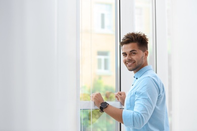 Photo of Portrait of handsome young man near window