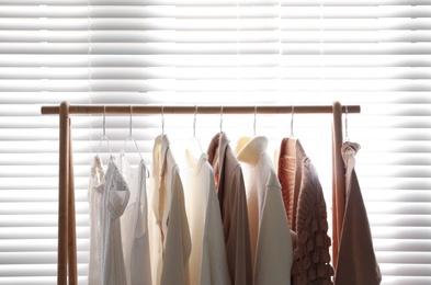 Photo of Rack with stylish women's clothes indoors. Modern interior design