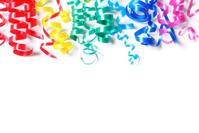 Photo of Colorful serpentine streamers on white background, top view