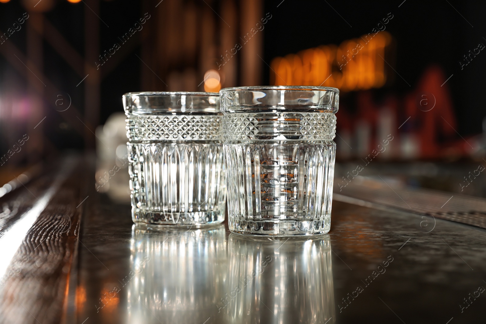 Photo of Empty clean glasses on counter in modern bar