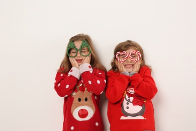 Kids in Christmas sweaters and festive glasses on white background